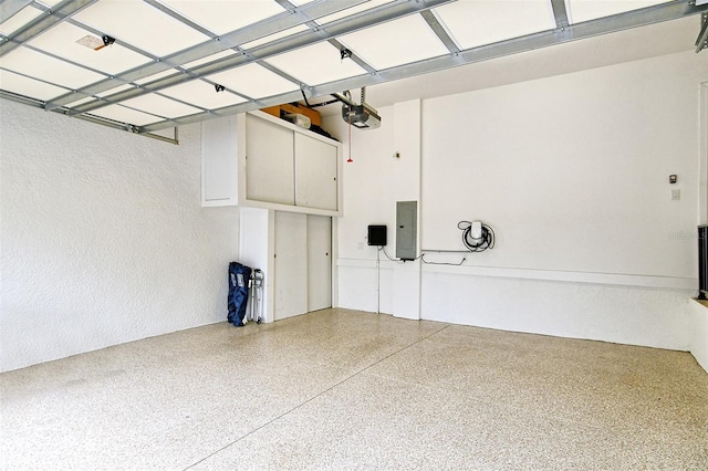 garage with a garage door opener and electric panel