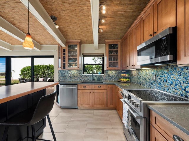 kitchen featuring sink, tasteful backsplash, hanging light fixtures, beamed ceiling, and stainless steel appliances