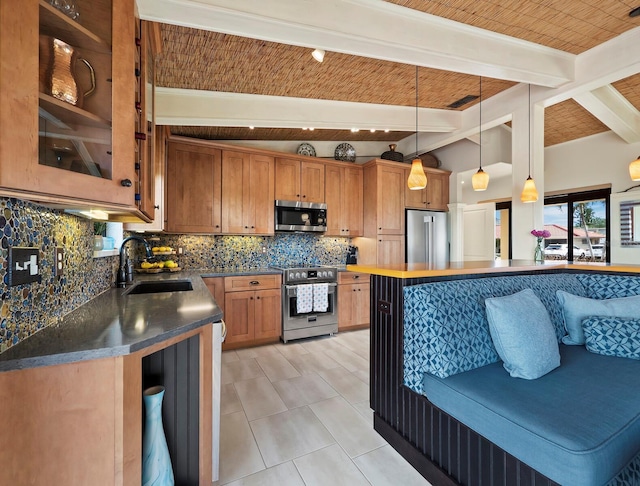 kitchen with sink, appliances with stainless steel finishes, tasteful backsplash, a kitchen bar, and decorative light fixtures