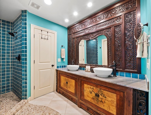 bathroom featuring vanity, a tile shower, and tile patterned floors