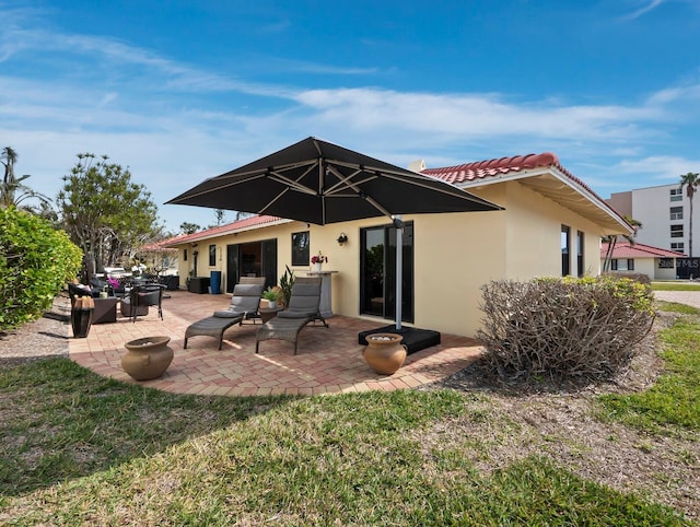 rear view of house with a yard and a patio area