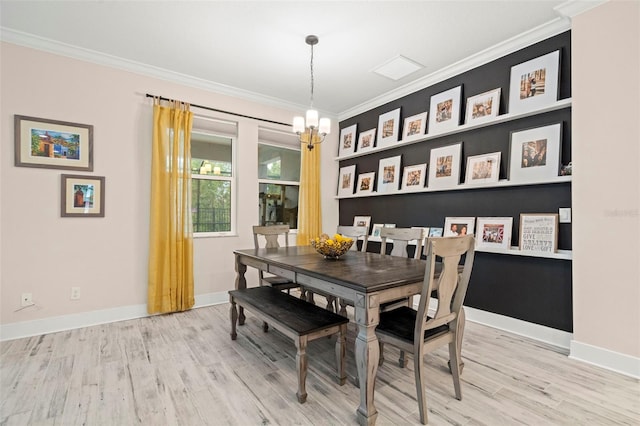 dining space featuring an inviting chandelier, light wood-type flooring, and ornamental molding