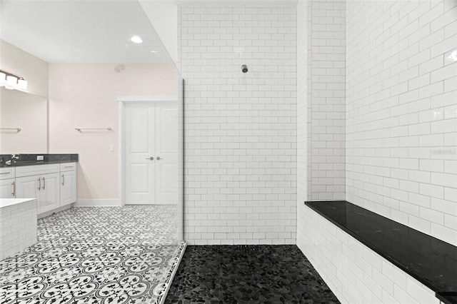 bathroom featuring tiled shower and vanity