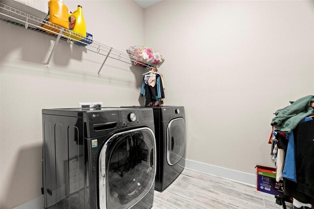 washroom featuring independent washer and dryer and light hardwood / wood-style floors