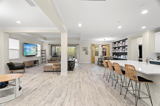 1012 Fernleaf Run, Bradenton, FL 34212 - living room with ornamental molding, light wood finished floors, recessed lighting, and baseboards