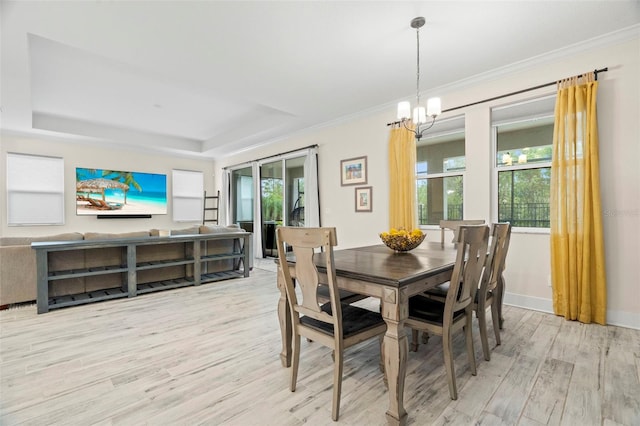 1012 Fernleaf Run, Bradenton, FL 34212 - dining room with light wood finished floors, a tray ceiling, a chandelier, crown molding, and baseboards