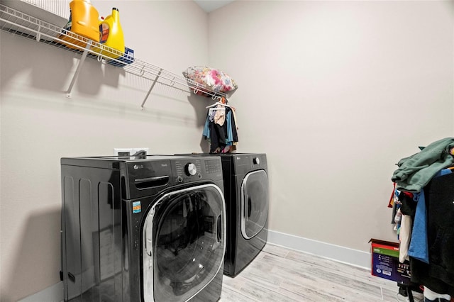 1012 Fernleaf Run, Bradenton, FL 34212 - laundry area featuring washing machine and dryer, wood finished floors, and baseboards