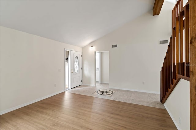 foyer featuring beam ceiling, high vaulted ceiling, and light wood-type flooring