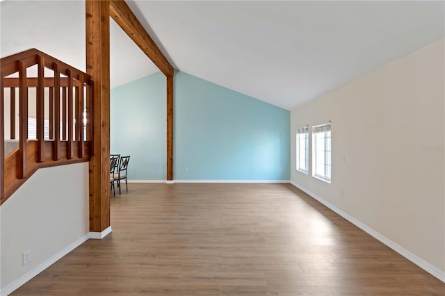 unfurnished room featuring hardwood / wood-style floors and vaulted ceiling with beams