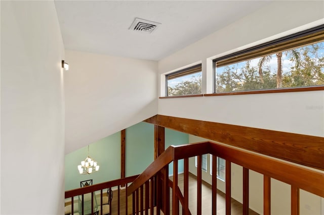 stairs with a chandelier