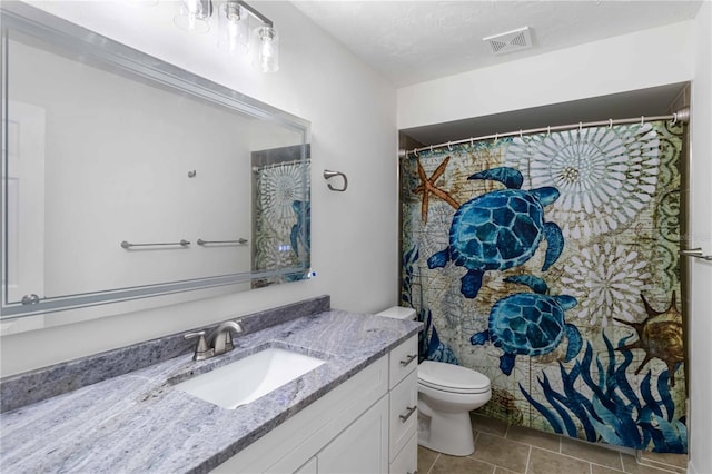 bathroom featuring vanity, toilet, and tile patterned flooring