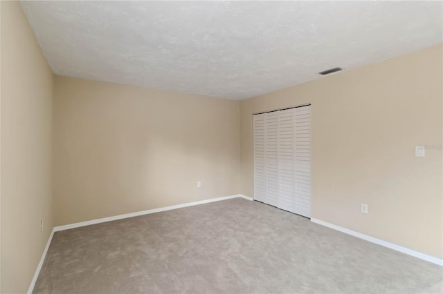 spare room featuring a textured ceiling and carpet