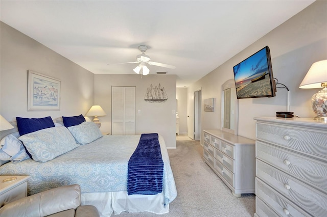 bedroom featuring ceiling fan, a closet, and light carpet