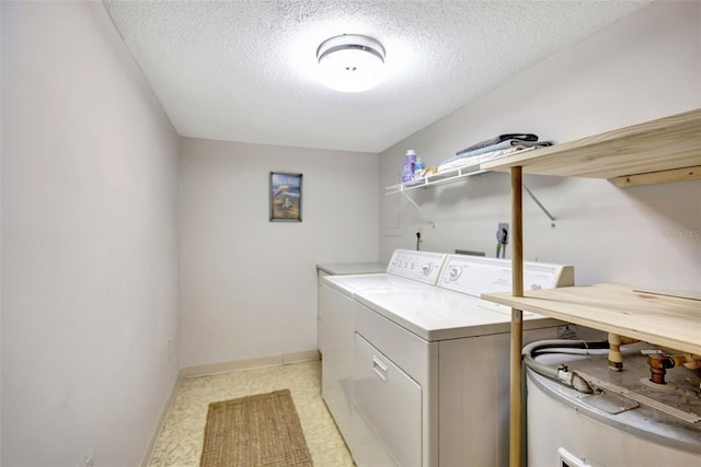 laundry area featuring washing machine and clothes dryer and a textured ceiling