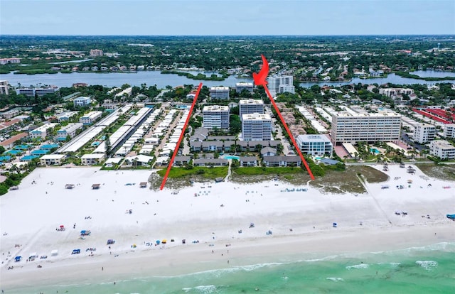 drone / aerial view featuring a water view and a view of the beach