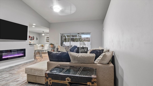 living room with hardwood / wood-style flooring, ceiling fan, and lofted ceiling