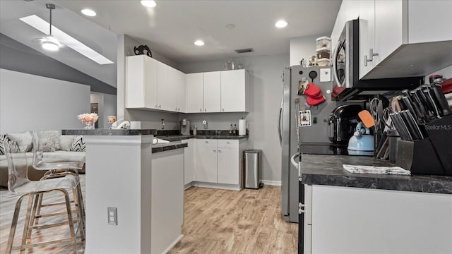 kitchen with white cabinetry, lofted ceiling, light hardwood / wood-style flooring, and kitchen peninsula