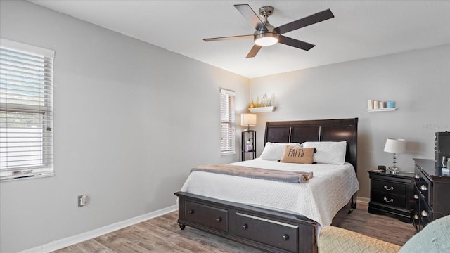 bedroom featuring ceiling fan, multiple windows, and hardwood / wood-style flooring