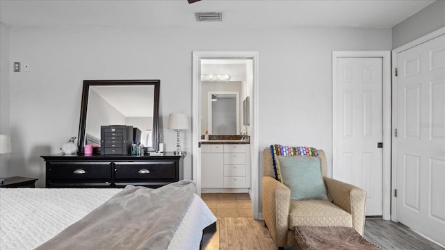 bedroom featuring light hardwood / wood-style flooring and ensuite bathroom