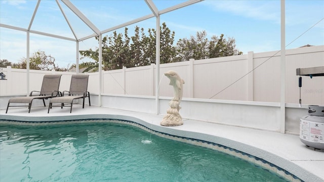 view of swimming pool with glass enclosure, a patio area, and pool water feature