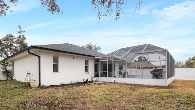 rear view of house featuring a lawn and a lanai