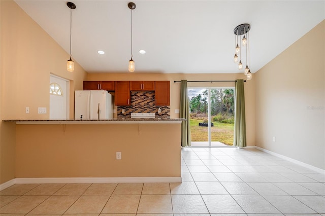 kitchen featuring pendant lighting, light tile patterned floors, white refrigerator, and lofted ceiling