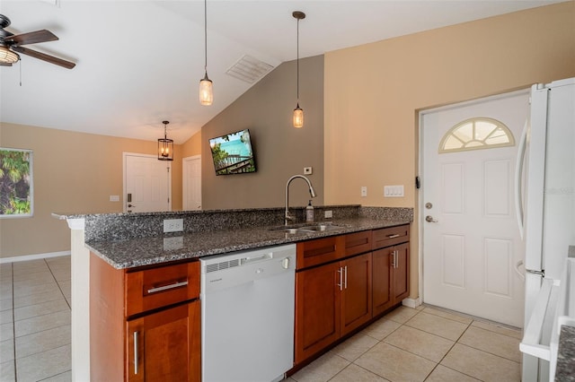 kitchen with sink, dark stone countertops, white appliances, and pendant lighting