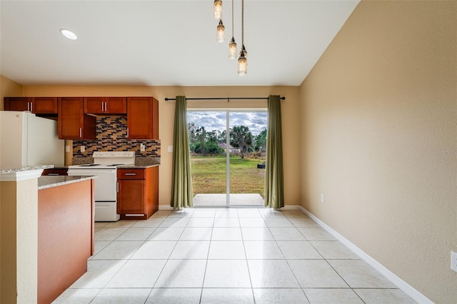 kitchen with decorative light fixtures, light tile patterned floors, light stone counters, white appliances, and decorative backsplash