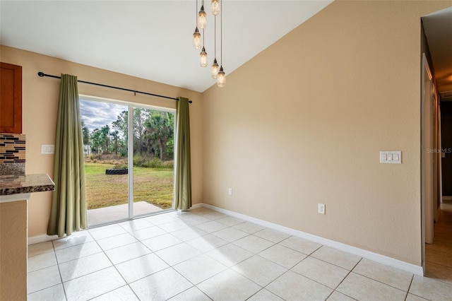 unfurnished dining area featuring vaulted ceiling and light tile patterned floors