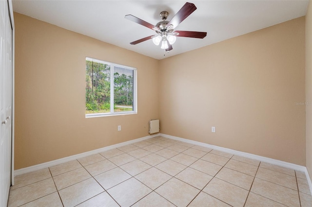 tiled spare room featuring ceiling fan