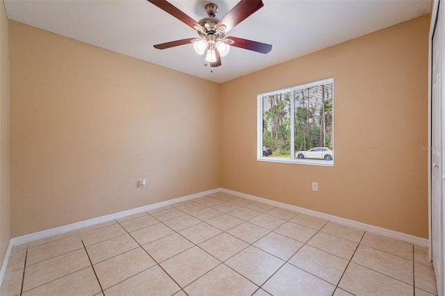 tiled spare room featuring ceiling fan