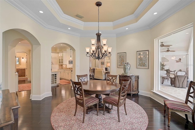 dining space featuring ornamental molding, dark hardwood / wood-style floors, and a tray ceiling