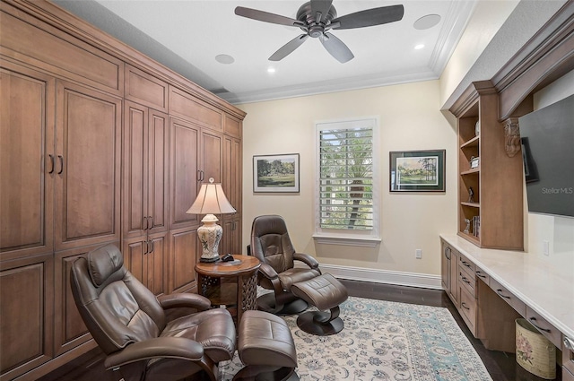 sitting room with crown molding, ceiling fan, dark hardwood / wood-style flooring, and built in desk