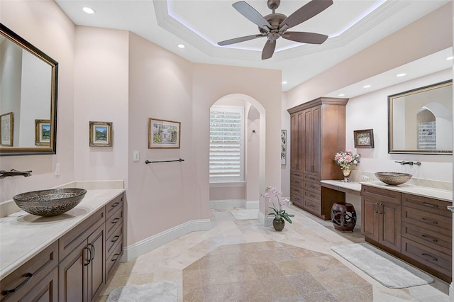 bathroom featuring ceiling fan, vanity, and a tray ceiling