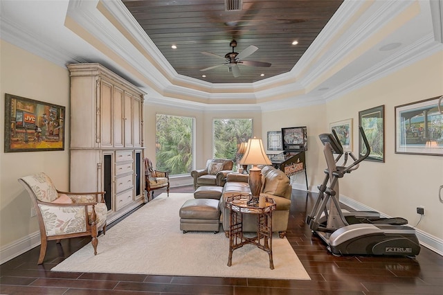 living area with crown molding, a tray ceiling, and ceiling fan