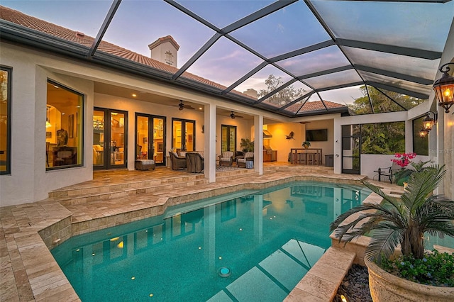 view of swimming pool with a patio, a lanai, ceiling fan, and a bar