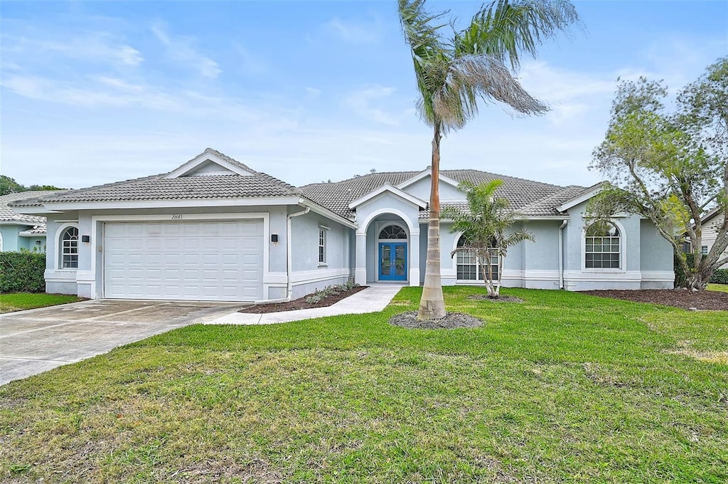 single story home featuring french doors, a garage, and a front yard