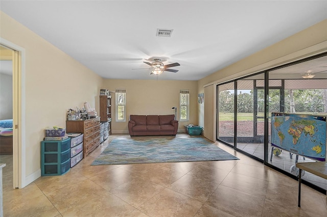 tiled living room featuring ceiling fan and a healthy amount of sunlight