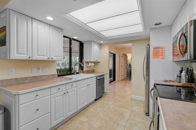 kitchen featuring light tile patterned floors, appliances with stainless steel finishes, sink, and white cabinets