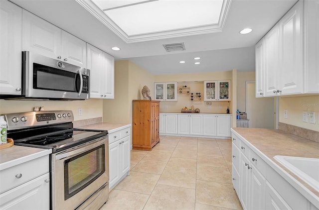 kitchen with white cabinetry, light tile patterned floors, crown molding, and appliances with stainless steel finishes