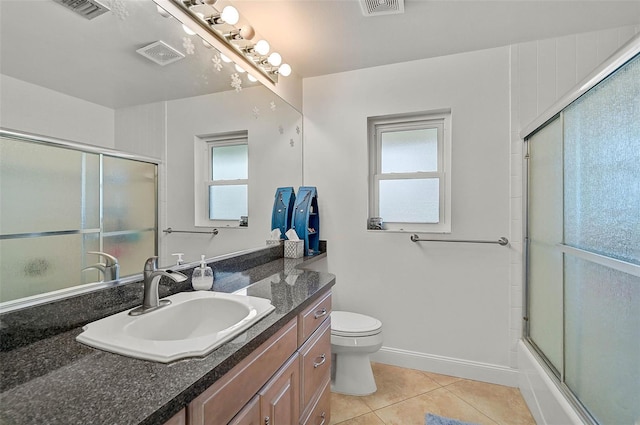 full bathroom featuring combined bath / shower with glass door, vanity, a wealth of natural light, tile patterned floors, and toilet