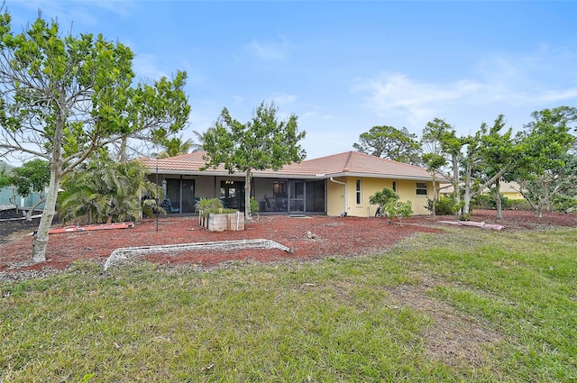 back of house with a lawn and a sunroom