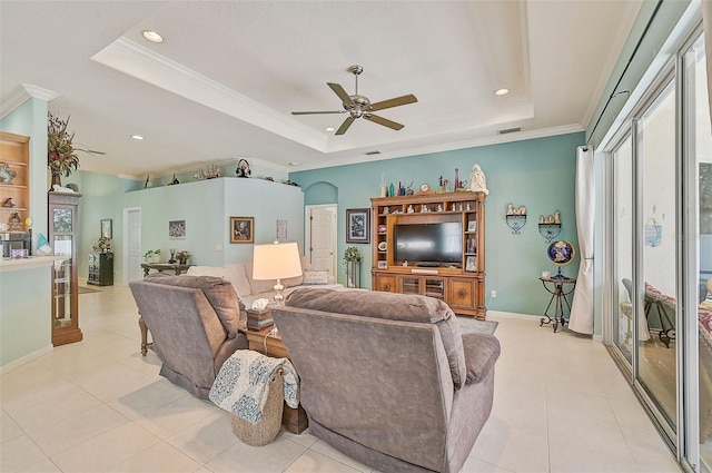 living room featuring ornamental molding, a raised ceiling, ceiling fan, and light tile patterned flooring