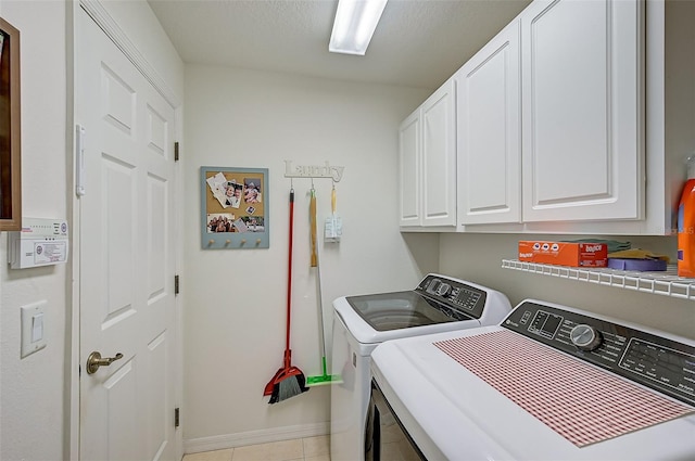 laundry room with cabinets, light tile patterned floors, and independent washer and dryer