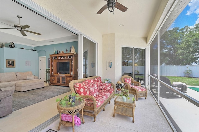 sunroom / solarium with ceiling fan and a tray ceiling