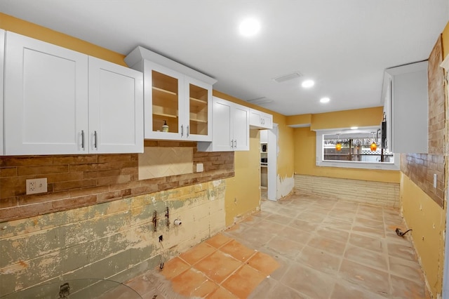 kitchen with decorative backsplash and white cabinets