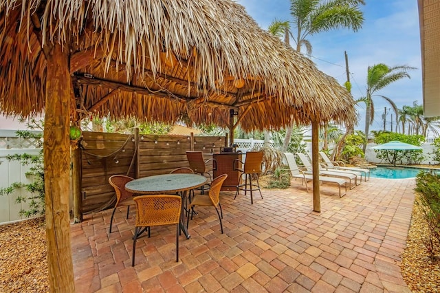 view of patio / terrace with a fenced in pool, a gazebo, and exterior bar