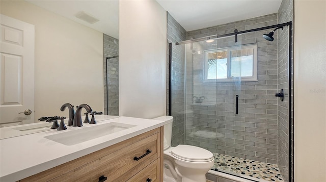 bathroom featuring toilet, a stall shower, visible vents, and vanity