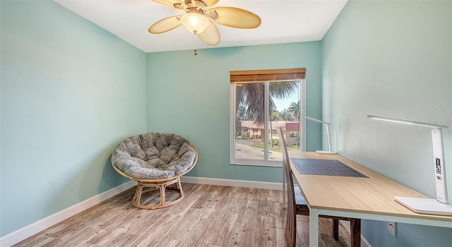 home office with baseboards, ceiling fan, and light wood-style floors