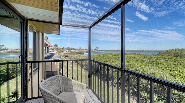 sunroom featuring a water view